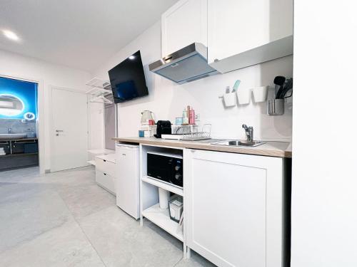 a white kitchen with a sink and a counter at La Bouganville in Assisi