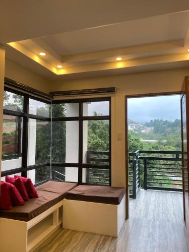 a room with a bed and large windows at Mountain Sunctuary-F1 2 Bedroom with nature view in Baguio