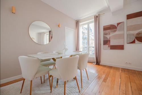 une salle à manger avec une table, des chaises et un miroir dans l'établissement CIA - Champs Élysées Delight, à Paris
