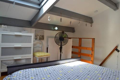 une chambre avec un lit et une chaise dedans dans l'établissement SP490-165 Appartement 2 pièces mezzanine SAINT PIERRE LA MER, à Saint Pierre La Mer