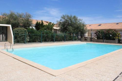 une grande piscine bleue devant un immeuble dans l'établissement SP490-165 Appartement 2 pièces mezzanine SAINT PIERRE LA MER, à Saint Pierre La Mer