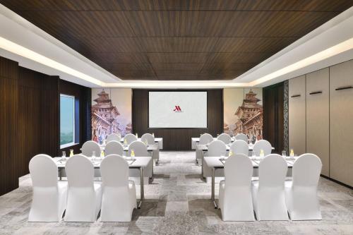 a conference room with white chairs and a projection screen at Kathmandu Marriott Hotel in Kathmandu