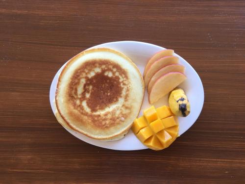a white plate topped with a cup of coffee and fruit at R2R Bayview Inn in Coron