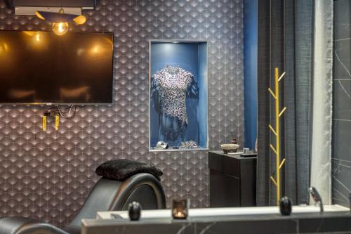 a dressing room with a mirror and a dress in a mirror at Love Room L'Aixtase - Oasis Romantique à Aix-les-Bains in Aix-les-Bains