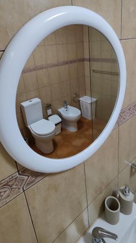 a bathroom with a toilet and a sink in a mirror at A Casa da Loja in Lagoa