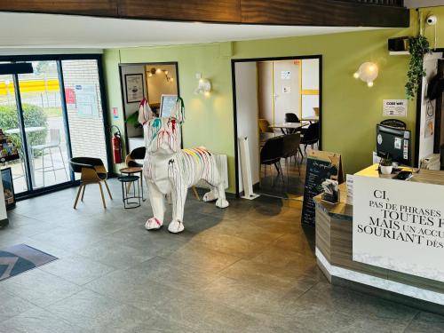 a room with a statue of a horse in a store at Kyriad Toulouse Sud - Roques in Roques Sur Garonne