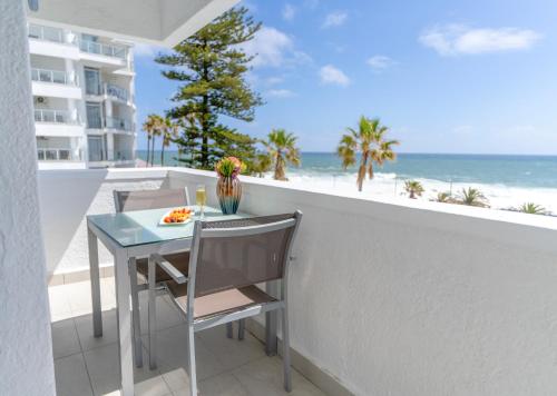 a table and chairs on a balcony with the beach at Peninsula All Suite Hotel by Dream Resorts in Cape Town