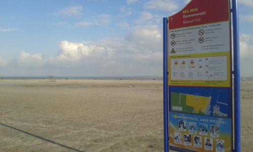 a sign in the middle of a desert with a field at Marijanas Ferienhof 1, Urlaub mit viel Platz zwischen Dornumersiel und Bensersiel, gehört zum Café Kunterbunt in Middelsbur