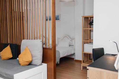 a room with a bedroom with a bed and a desk at Estúdio no Porto in Porto