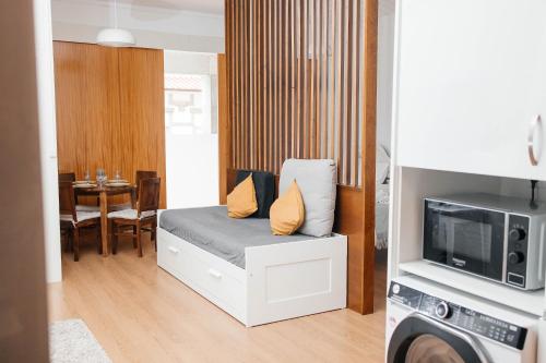 a small room with a bed and a dining room at Estúdio no Porto in Porto