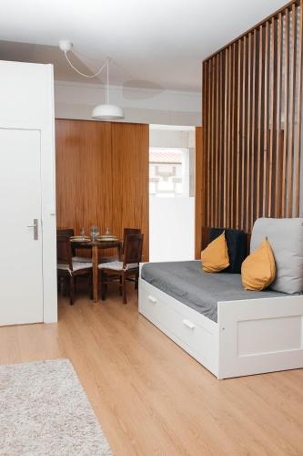 a bedroom with a bed and a dining room with a table at Estúdio no Porto in Porto