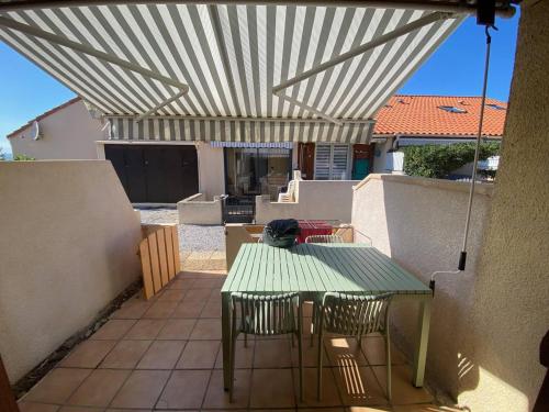 d'une terrasse avec une table et des chaises sous un auvent. dans l'établissement Villa cosy 4 pers, terrasse, parking privé à Port Leucate - FR-1-81-628, à Port-Leucate