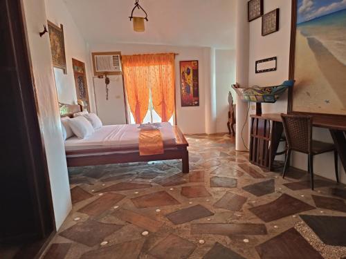 a bedroom with a bed and a table and a window at Casa de Arte in Boracay