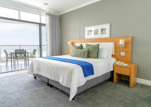 a bedroom with a bed with a view of the ocean at Peninsula All Suite Hotel by Dream Resorts in Cape Town