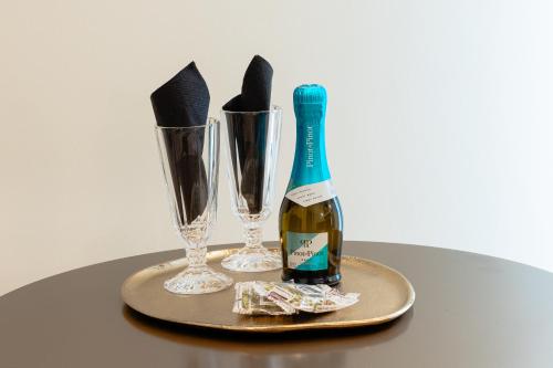 a table with a bottle of wine and two wine glasses at Hera Rooms and Suites in Agrigento