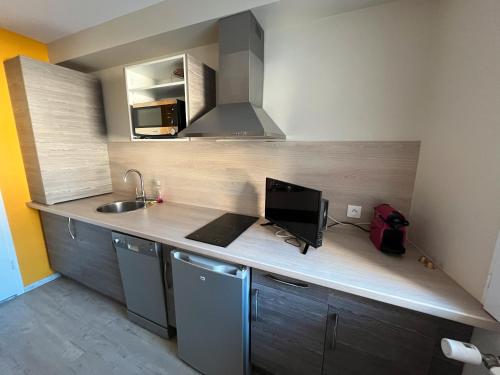 a kitchen with a counter with a computer on it at Logis Les Forges in Arvillard