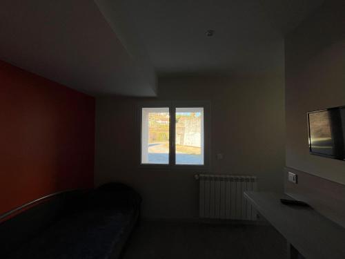 a small room with a couch and a window at Logis Les Forges in Arvillard