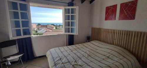 une chambre avec un lit et deux fenêtres dans l'établissement SP460-032 Maison 4 pièces 5 couchages SAINT PIERRRE LA MER, à Saint Pierre La Mer