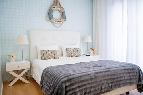 a bedroom with a bed and a mirror on the wall at By the Sea - Nazaré in Nazaré