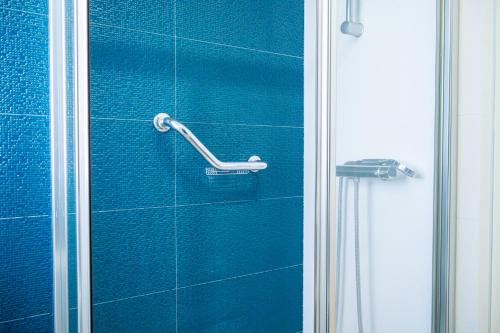 a shower with a blue tiled wall in a bathroom at By the Sea - Nazaré in Nazaré