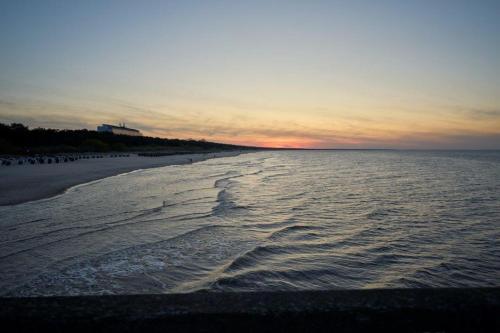 a view of a beach at sunset with the ocean at Strandhotel Luise von Preussen in Zinnowitz