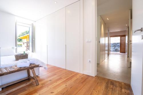 a living room with white walls and a wooden table at Portugal Active Atlantic Lodge in Afife