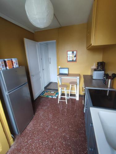 une petite cuisine avec une table et un réfrigérateur dans l'établissement Rouen gauche collé au jardin des plantes, à Rouen