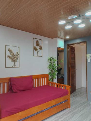a bedroom with a wooden bed with purple sheets at Mountain Sunctuary-S2 Unit with Breathtaking view in Baguio