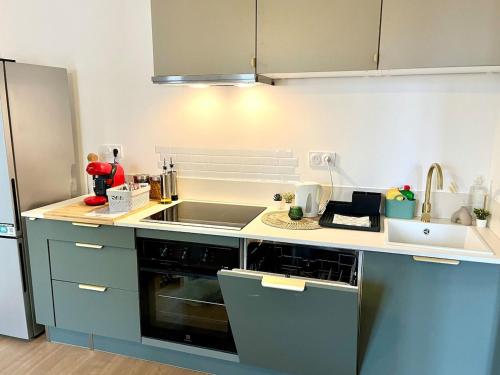 a kitchen with a sink and a stove at Cozy Margny - Neuf, Calme, Haut Débit & SmartTV in Margny-lès-Compiègne