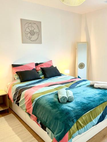 - une chambre avec un lit et une couverture colorée dans l'établissement Cozy Margny - Neuf, Calme, Haut Débit & SmartTV, à Margny-lès-Compiègne