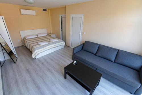 a living room with a couch and a bed at Хотелски комплекс САНЯ in Apriltsi
