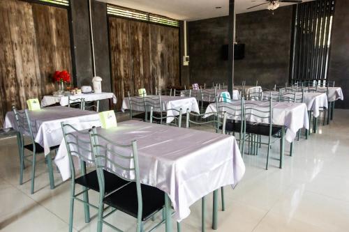 a room with tables and chairs with white tablecloths at Judy Park & Resort Buriram in Ban Nong Hua Wua