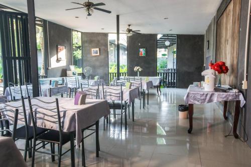 un comedor con mesas y sillas con flores. en Judy Park & Resort Buriram, en Ban Nong Hua Wua