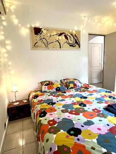 une chambre avec un lit avec une couette colorée dans l'établissement Appartement niché dans la verdure, à Aix-en-Provence