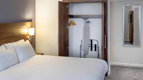 a bedroom with a white bed and a shower at Holiday Inn Liverpool City Centre by IHG in Liverpool