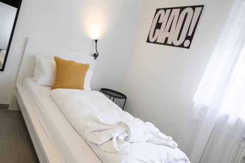 a white bed with a blanket on it in a room at EasyOne Apartments in Frankenthal