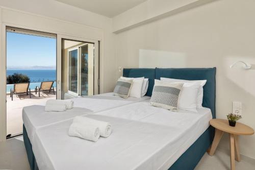 a bedroom with a large bed with a view of the ocean at Valtes Green by Vintage Travel in Corfu