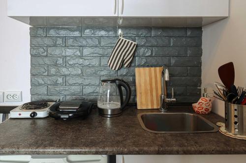 a kitchen counter with a sink and a stove at Ski In Out Apartment In New Gudauri For 4 in Gudauri