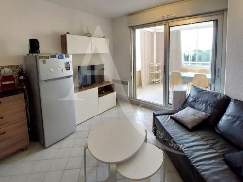 - un salon avec un canapé, un réfrigérateur et une table dans l'établissement A 2 pas des plages pour 4 personnes, à Sète