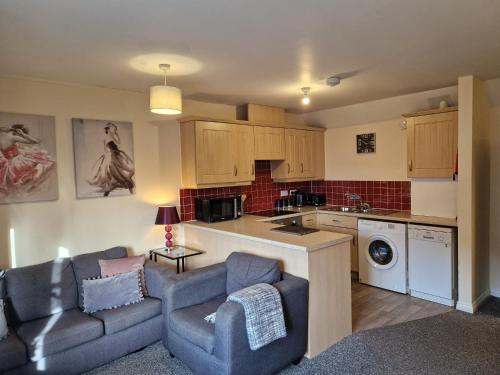 een woonkamer met een bank en een keuken bij Hereford - Mayflower Coach House, Modern 2 Bedroom Property With Parking, Located South Of Hereford City, Suitable For Small Family, Couple Or Contractors - Sleeps Up To 5 Guests - Hosted by RENTMYHOUSE in Hereford