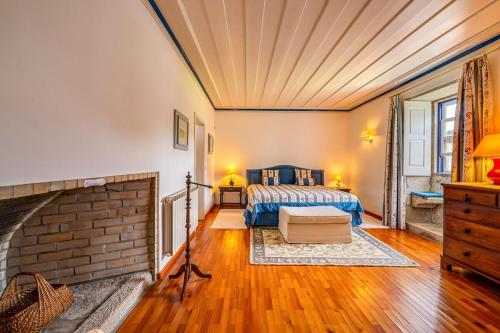 a bedroom with a bed and a brick fireplace at Portugal Active Oliveiras Farm in Viana do Castelo