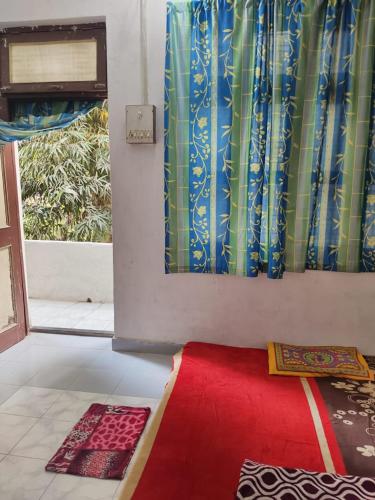 a room with a red rug and a window at Kumbh friends and family homestay in Prayagraj