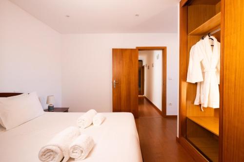 a bedroom with a bed with towels on it at Portugal Active Encosta House in Viana do Castelo