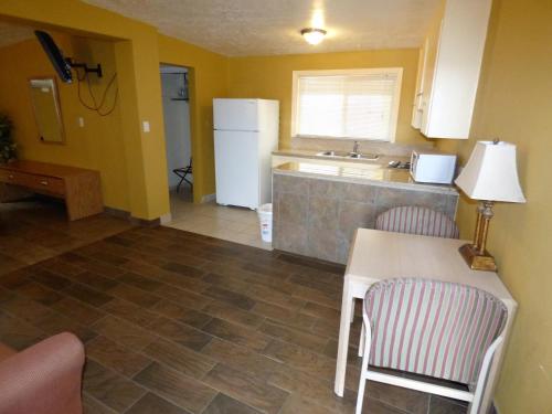 a kitchen with a table and chairs and a refrigerator at Sands Motel in St. George