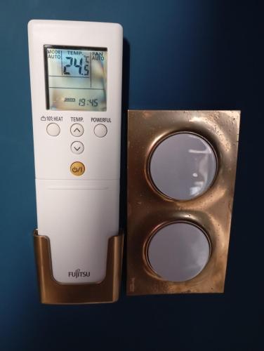 Un nintendo à distance à côté d'une paire d'acèdres dans l'établissement Ma Petite Chambre Parisienne, à Pleugueneuc