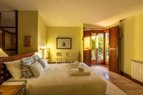 una camera da letto con un grande letto bianco in una stanza di Carreços Beach Farm a Viana do Castelo