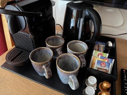 a tray with four coffee cups on a counter at Hotel in the HEART of the Alps in Uttendorf
