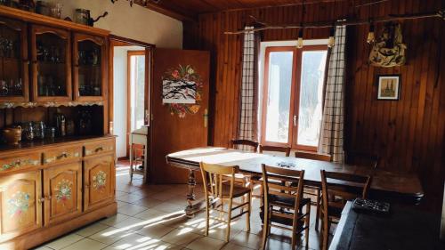 une cuisine avec une table et des chaises dans une pièce dans l'établissement Maison Chartrousine nature park, à Saint-Pierre-dʼEntremont