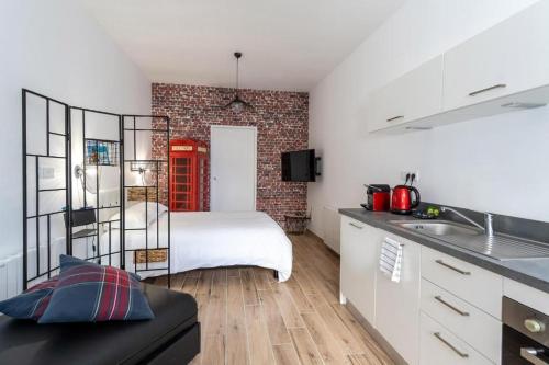 a bedroom with a bed and a brick wall at Koaloft in Lorient