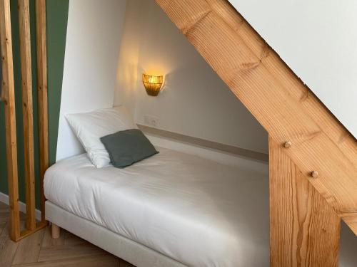 a small bed with a green pillow on it at La Tour en Seine in Les Authieux-sur-le-Port-Saint-Ouen
